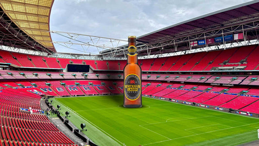 Giant Wrexham Export Lager bottle inside Wembley stadium