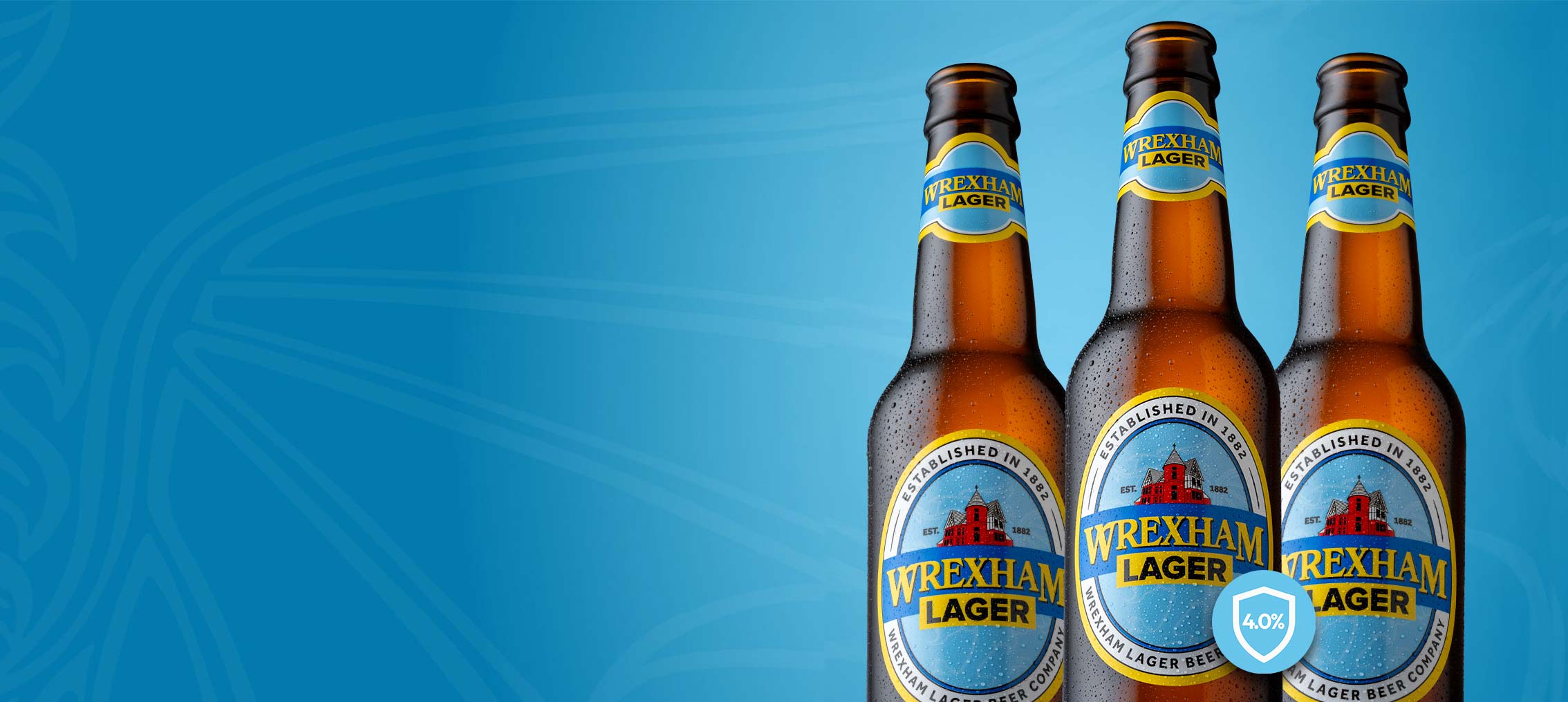 Three bottles of Wrexham Lager on a blue background