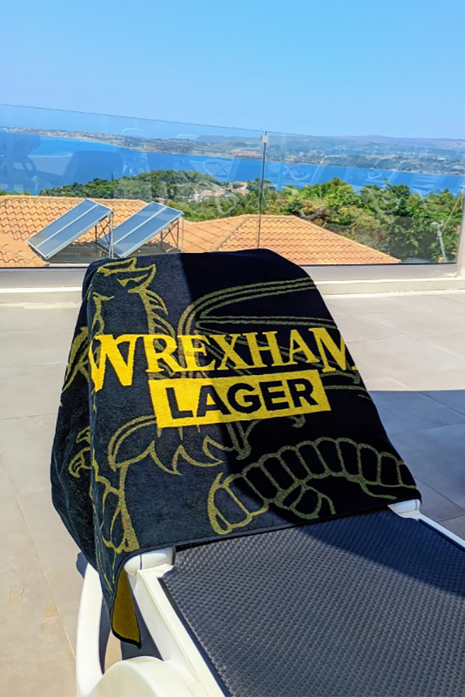 Wrexham Lager Beach Towel on sunbed